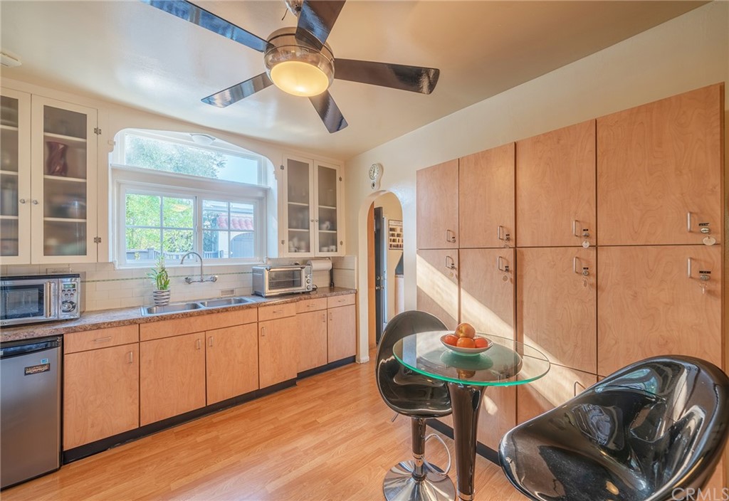 1853 Allen Avenue Pasadena, CA 91104 - Photo 15 of 38 a kitchen with stainless steel appliances granite countertop a sink a stove a dining table and chairs with wooden floor