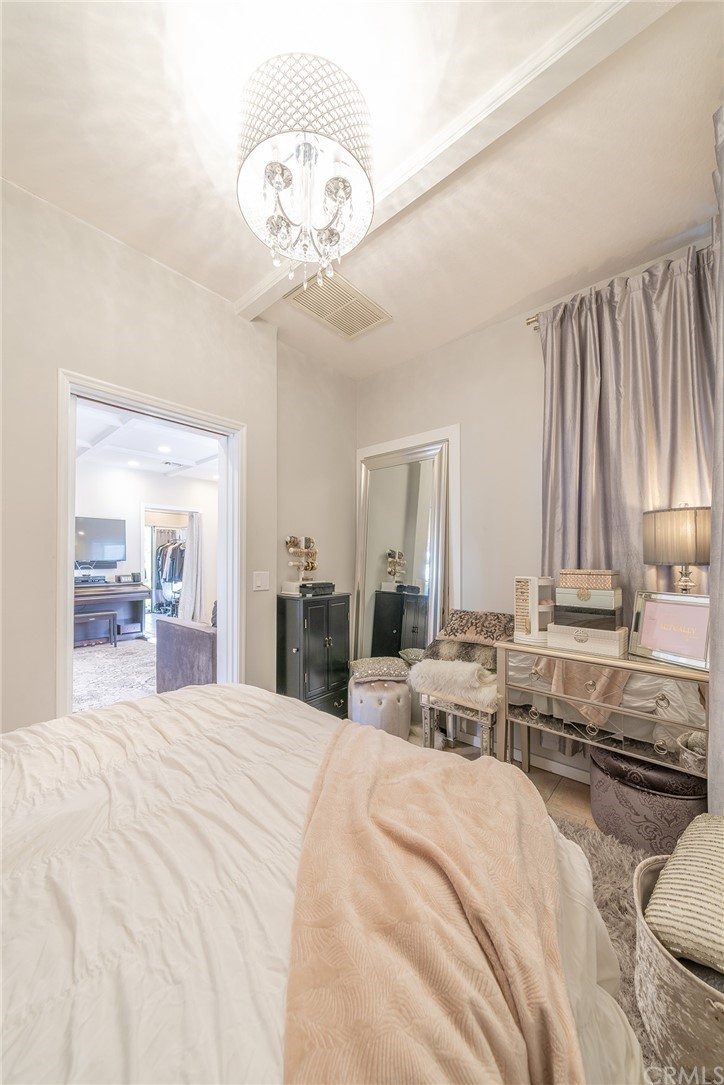 1853 Allen Avenue Pasadena, CA 91104 - Photo 22 of 38 a large bedroom with a large bed and a chandelier