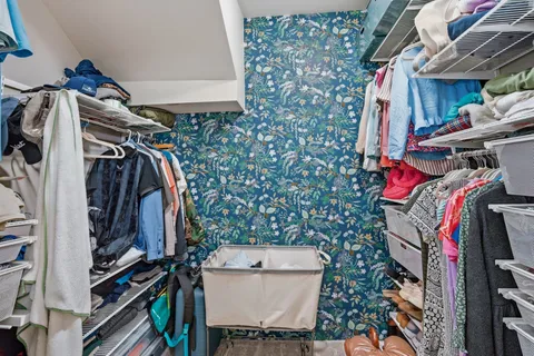 a view of walk in closet with clothes and shoes