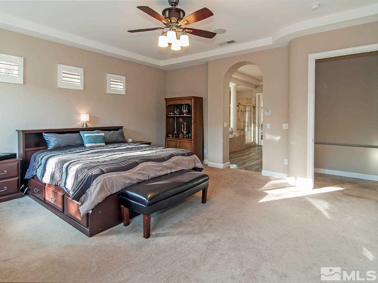 2690 Strathmore Court Reno, NV 89521 - Photo 12 of 25 a bedroom with a bed lamp and a chandelier