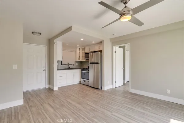 a kitchen with stainless steel appliances a refrigerator sink and white cabinets