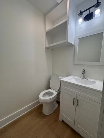 a bathroom with a toilet sink and mirror