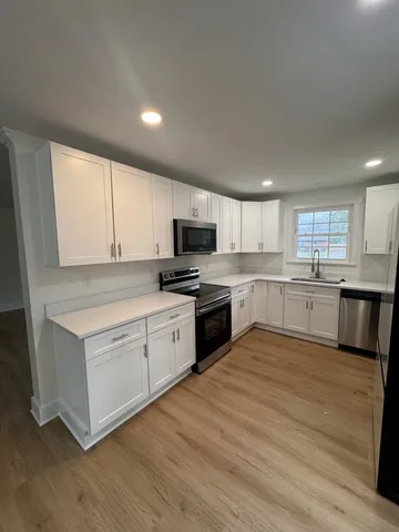a kitchen with granite countertop white cabinets and white appliances