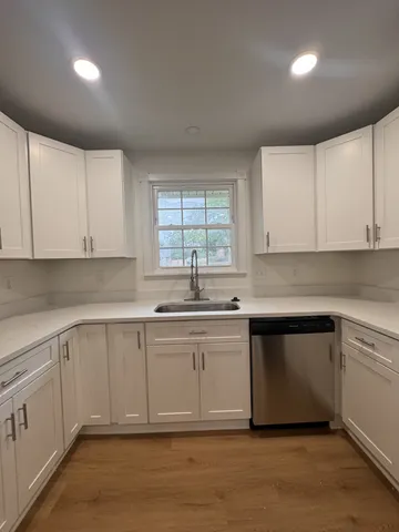 a kitchen with granite countertop white cabinets and white appliances