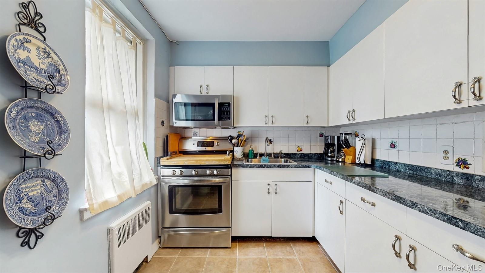 755 Bronx River Road, Unit 6C Bronxville, NY 10708 - Photo 10 of 22 a kitchen with stainless steel appliances granite countertop a sink a stove a washer and dryer