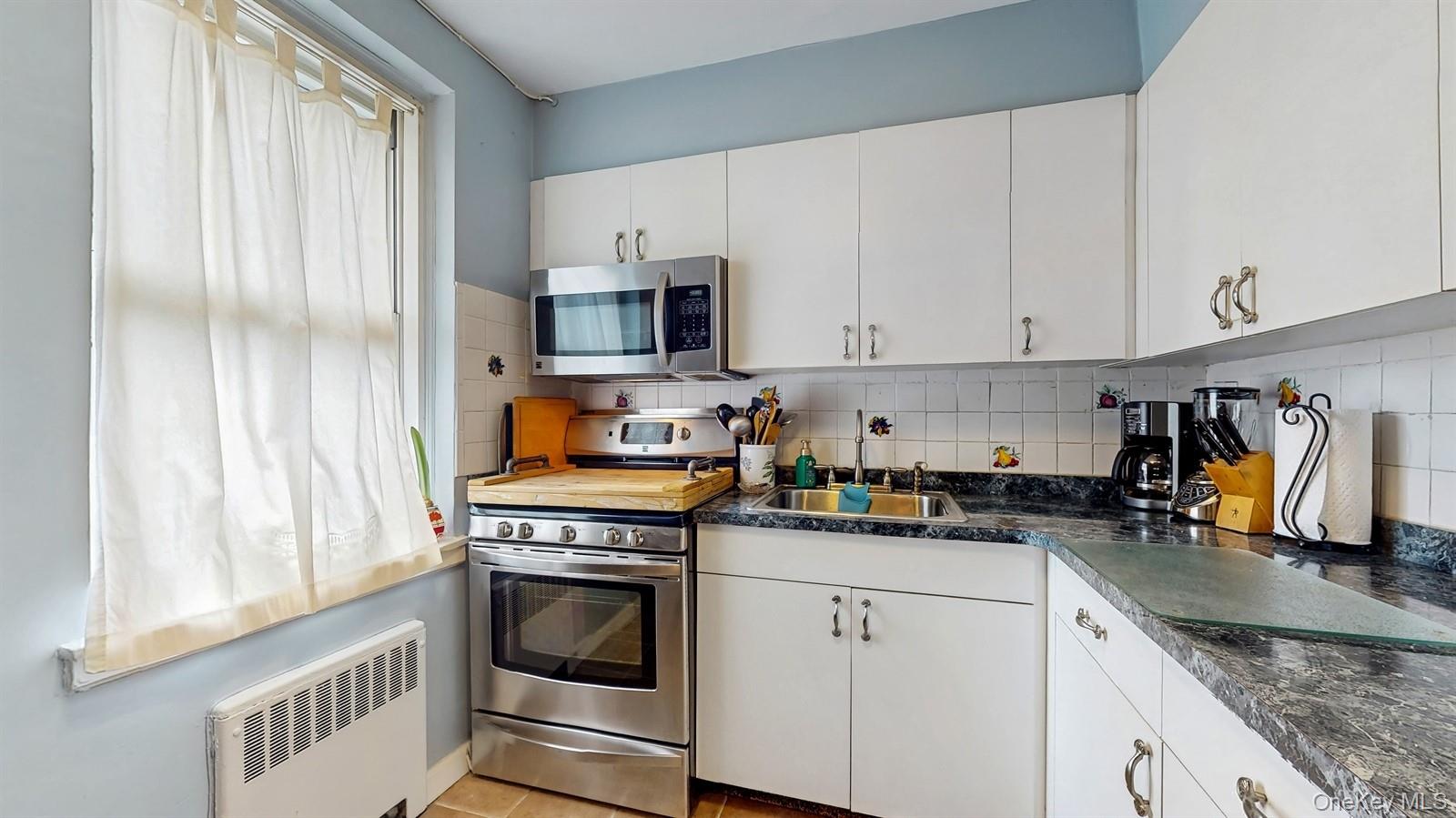 755 Bronx River Road, Unit 6C Bronxville, NY 10708 - Photo 11 of 22 a kitchen with stainless steel appliances granite countertop a stove a sink and a microwave