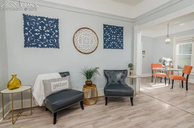 a living room with furniture a clock on wall and a window