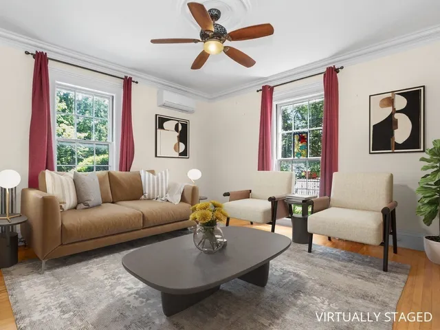 a living room with furniture a table and a large window