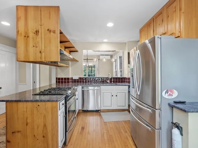 a kitchen with stainless steel appliances granite countertop a refrigerator and a stove top oven