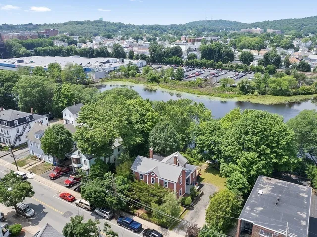 an aerial view of a house with a garden and lake view