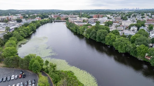 an aerial view of a house with a yard and lake view