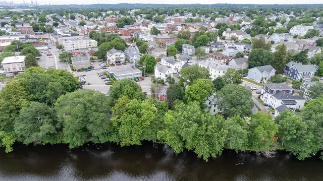 an aerial view of residential house with outdoor space and trees all around