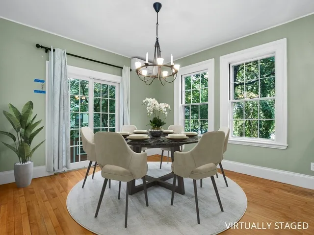 a dining room with furniture a chandelier and wooden floor