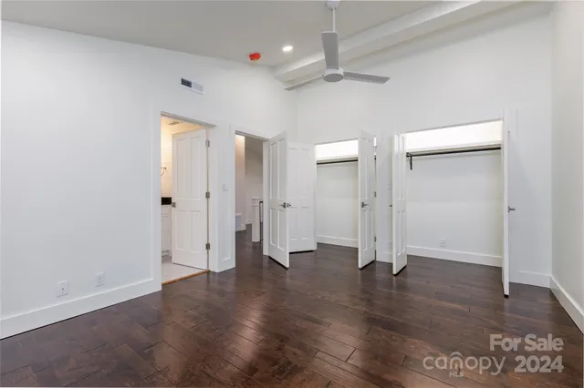 an empty room with wooden floor and mirror