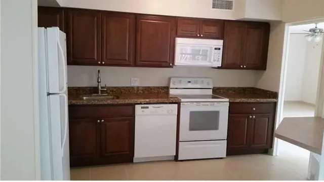 a kitchen with stainless steel appliances granite countertop a stove a refrigerator and a cabinets