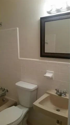 a bathroom with a toilet sink and mirror