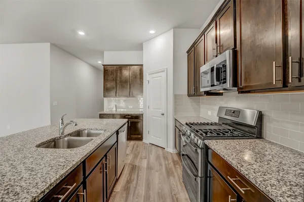 a kitchen with a stove sink and cabinets