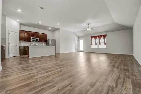 a view of kitchen with microwave a stove and wooden floor