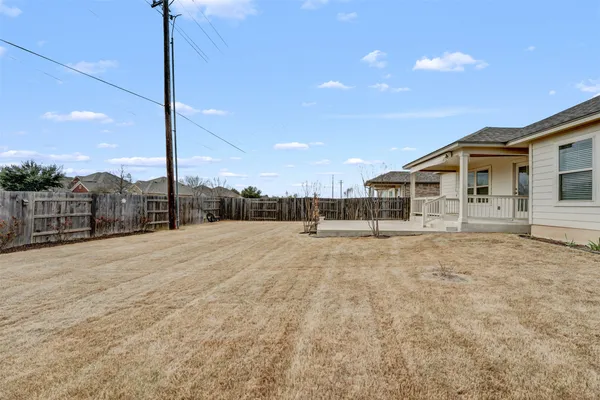 a view of a house with backyard and trees