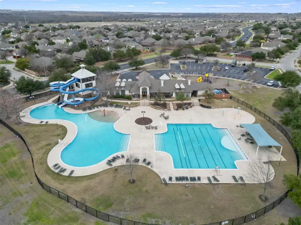 an aerial view of a swimming pool with a yard
