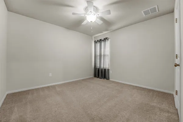 en empty room with windows and fan