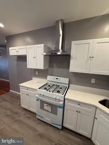 a white kitchen with stove top oven and cabinets