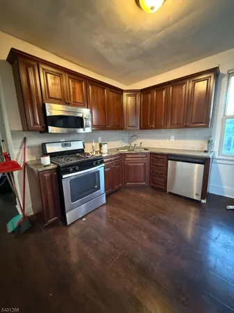 a kitchen with stainless steel appliances granite countertop a stove top oven a sink dishwasher and a microwave oven on the blue kitchen countertops