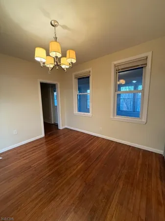 a view of a room with wooden floor and chandelier