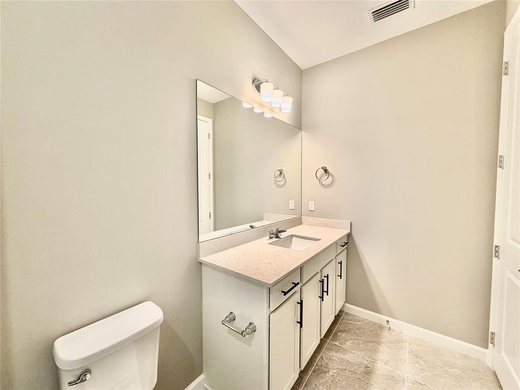 288 Southwest Sally Way Stuart, FL 34997 - Photo 12 of 22 a bathroom with a sink a toilet and mirror