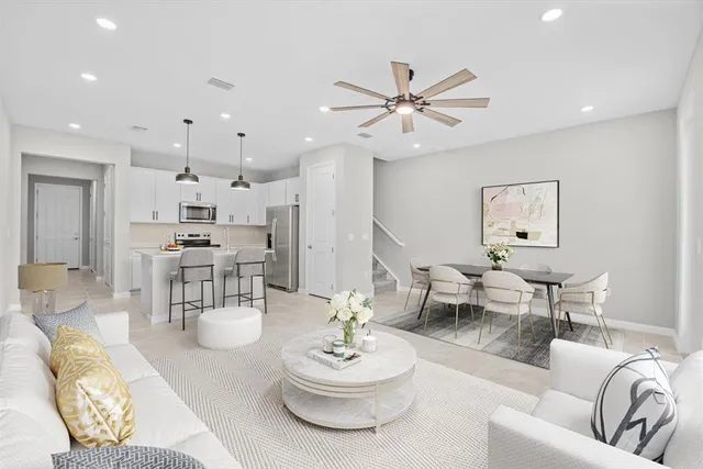 a living room with furniture and a dining table with kitchen view