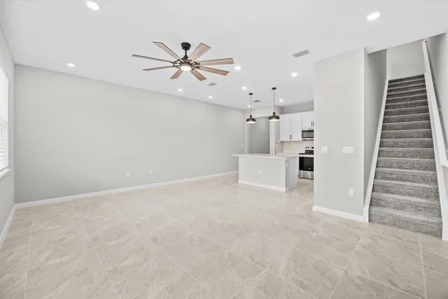 an empty room with white walls and ceiling fan