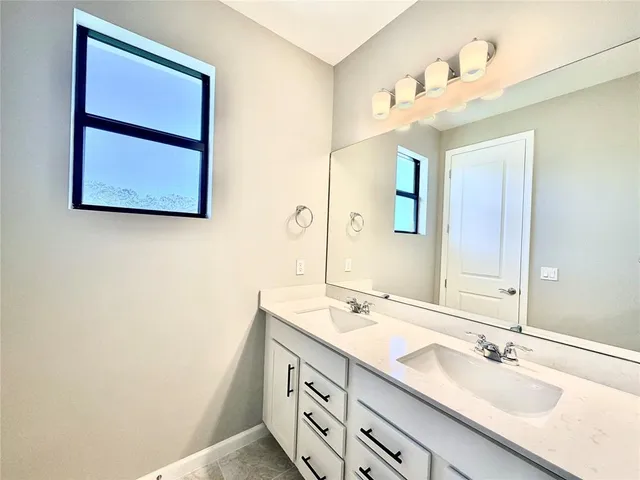 a bathroom with a double vanity sink and a mirror
