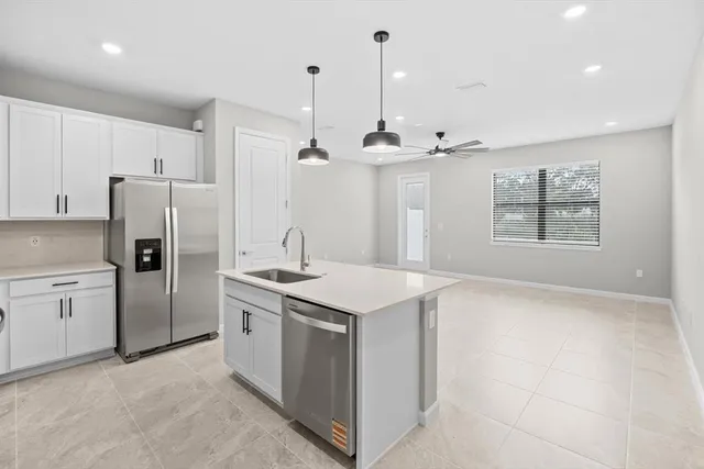 a kitchen with a refrigerator sink and cabinets
