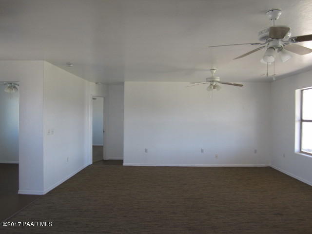 665 West Ahonen Road Paulden, AZ 86334 - Photo 3 of 18 an empty room with a ceiling fan and window