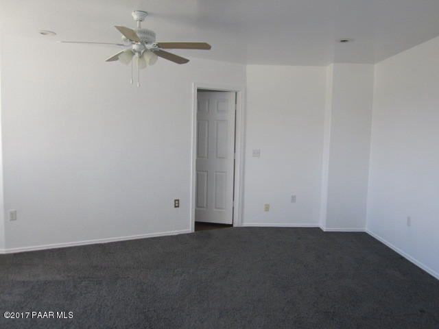 665 West Ahonen Road Paulden, AZ 86334 - Photo 7 of 18 an empty room with a ceiling fan and a window