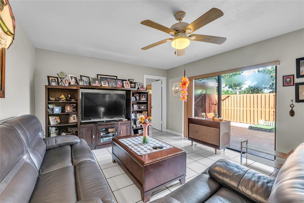 9104 Southwest 19th Place, Unit A Davie, FL 33324 - Photo 2 of 31 a living room with furniture and a flat screen tv