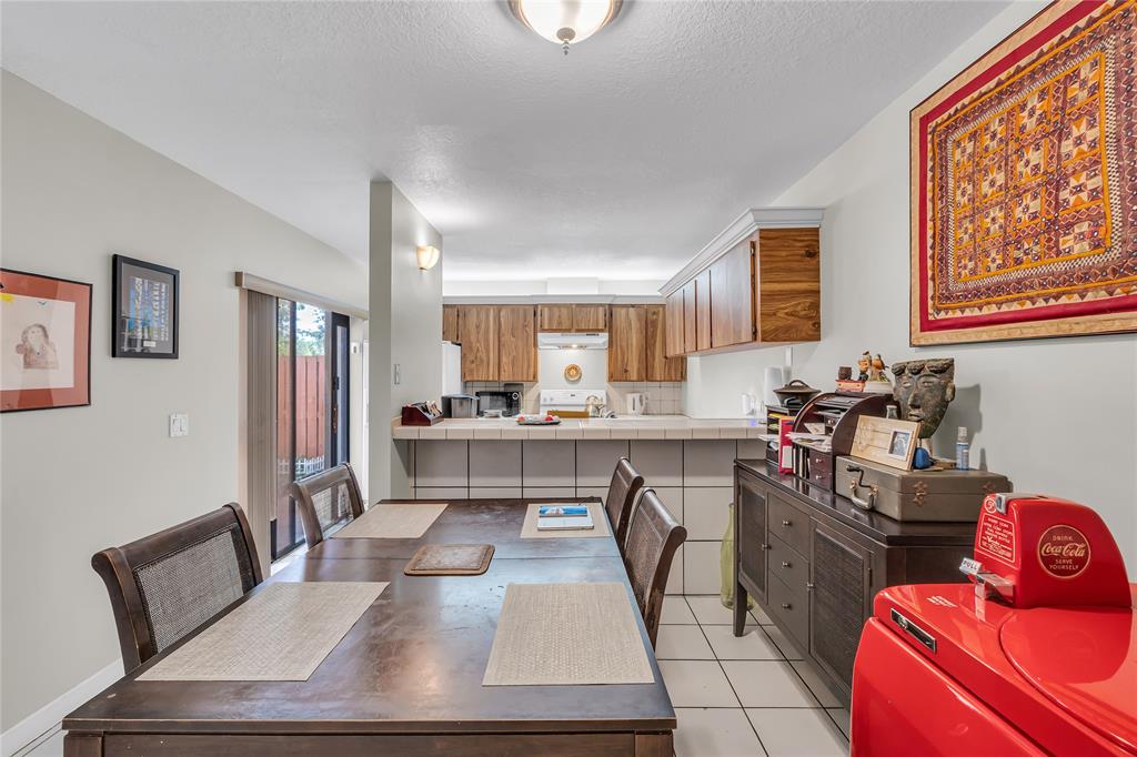 9104 Southwest 19th Place, Unit A Davie, FL 33324 - Photo 8 of 31 a kitchen with stainless steel appliances granite countertop a sink wooden cabinets and counter space