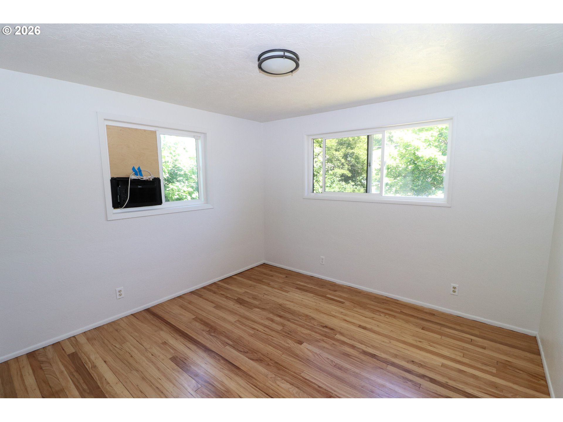 7077 Main Street Springfield, OR 97478 - Photo 19 of 34 an empty room with wooden floor and windows