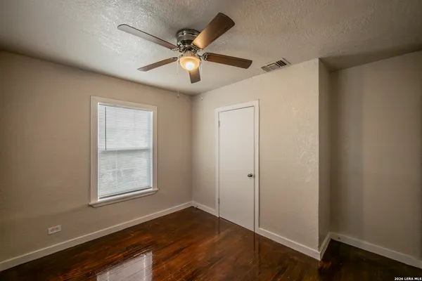 an empty room with windows and fan