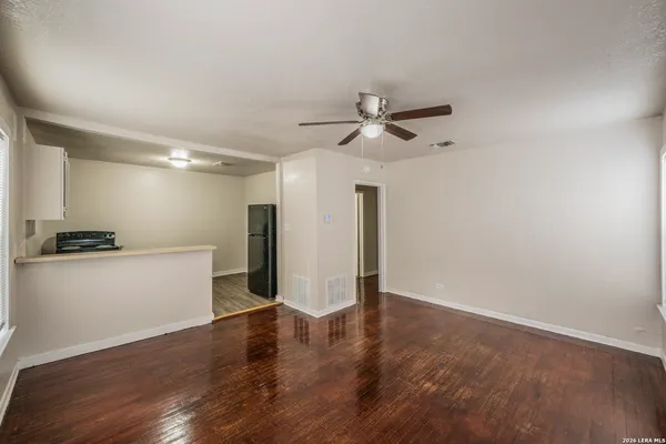 a view of a big room with wooden floor and a ceiling fan