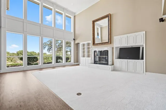 an empty room with windows and ceiling fan