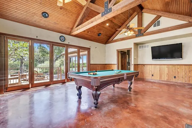 a view of a patio with table and chairs and a large tree