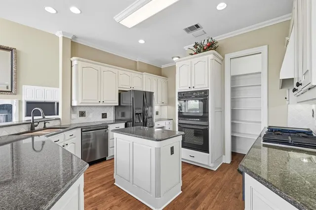 a kitchen with stainless steel appliances a sink stove and refrigerator