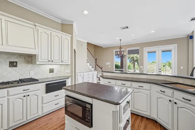 a kitchen with white cabinets and sink