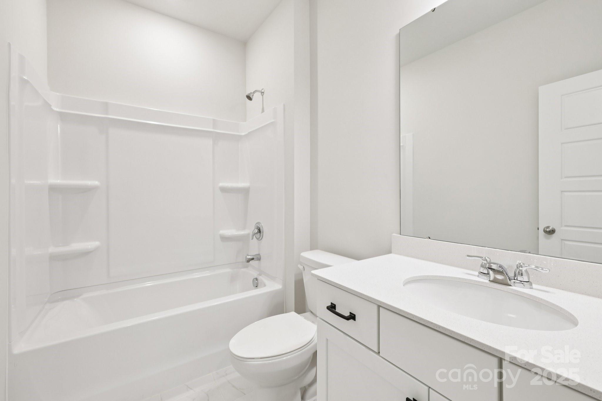 9612 Pointer Road, Unit 59 Huntersville, NC 28078 - Photo 28 of 43 a bathroom with a bathtub shower sink vanity mirror and toilet