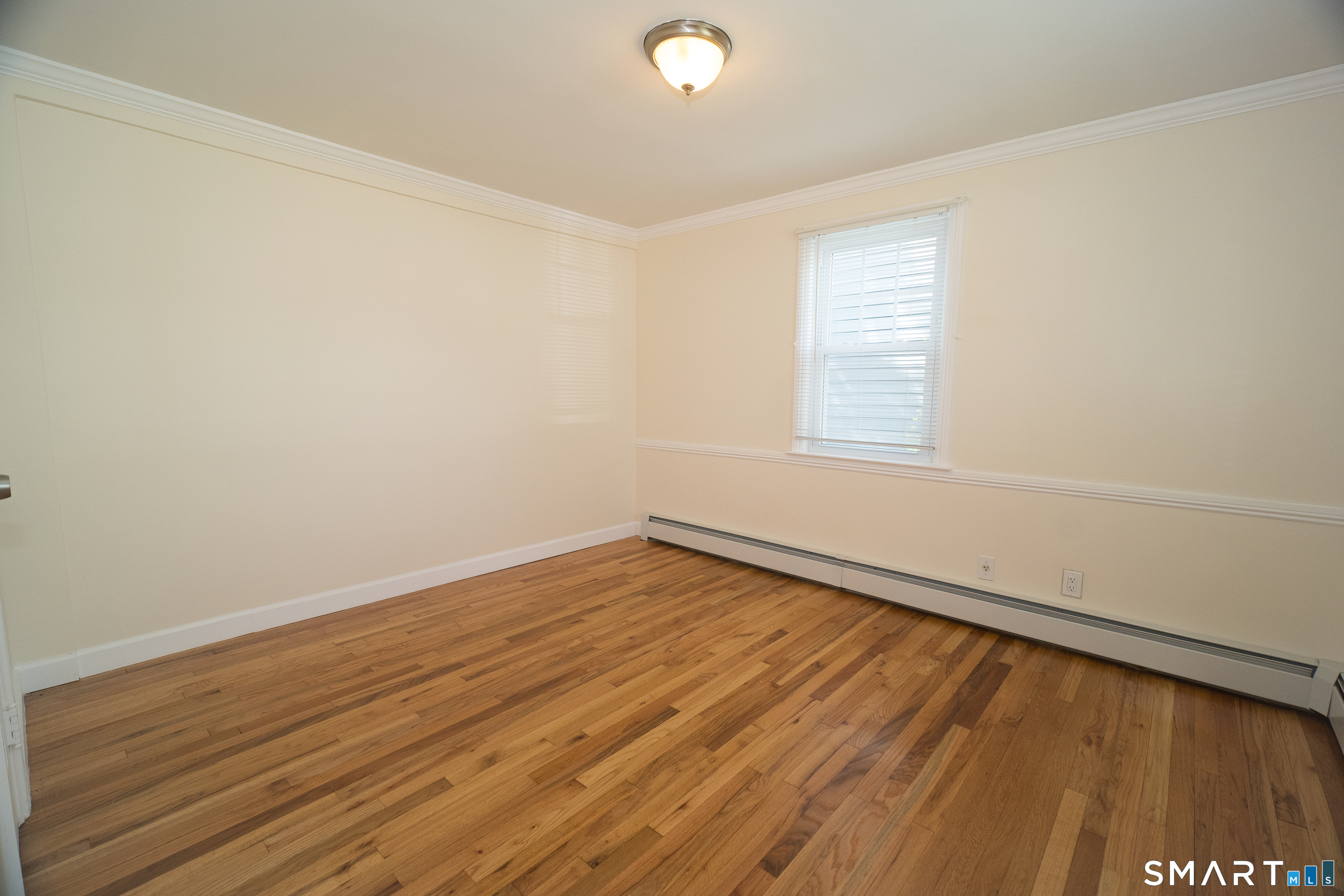 113 Clark Street Bridgeport, CT 06606 - Photo 11 of 27 an empty room with wooden floor and windows