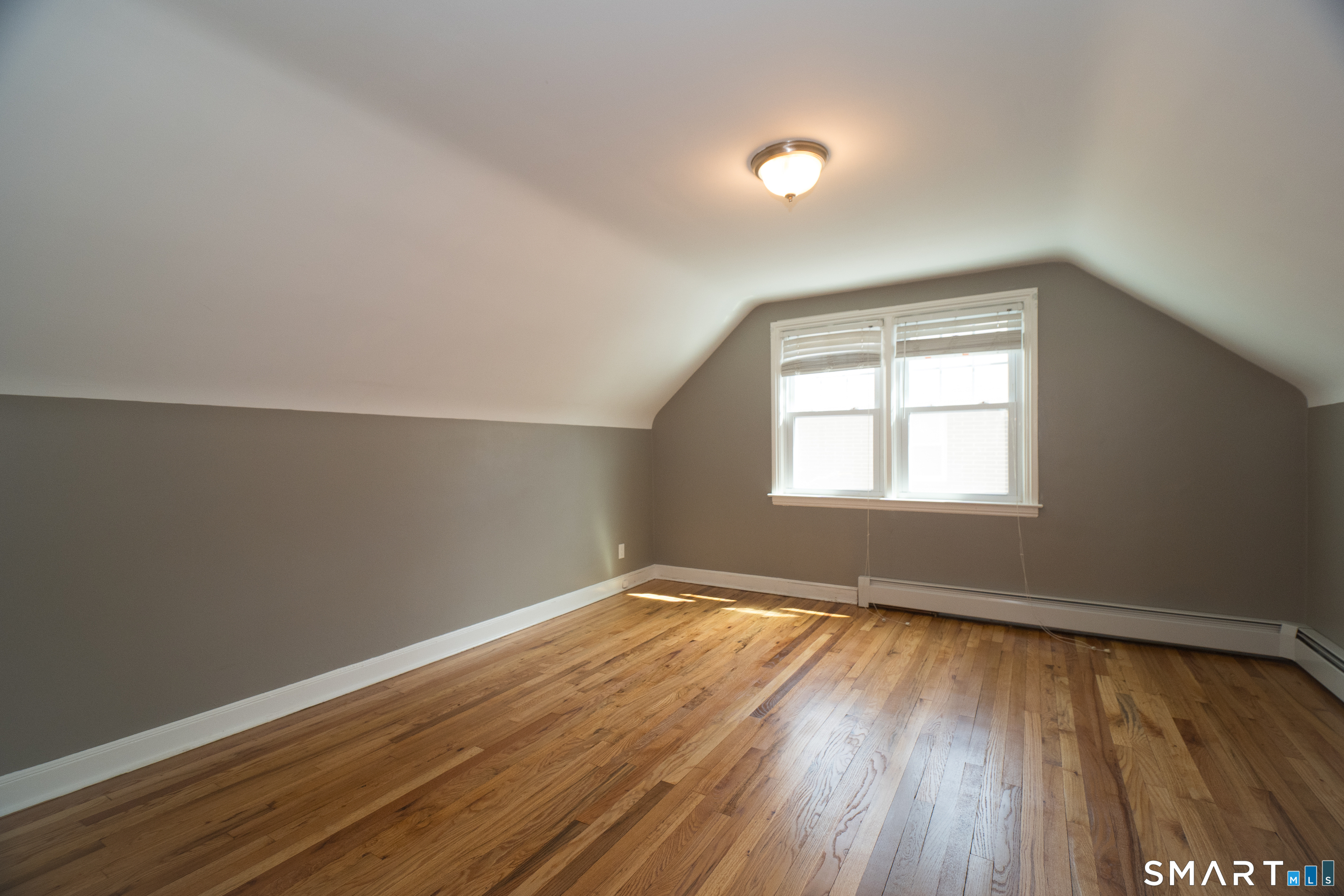 113 Clark Street Bridgeport, CT 06606 - Photo 17 of 27 an empty room with wooden floor and windows