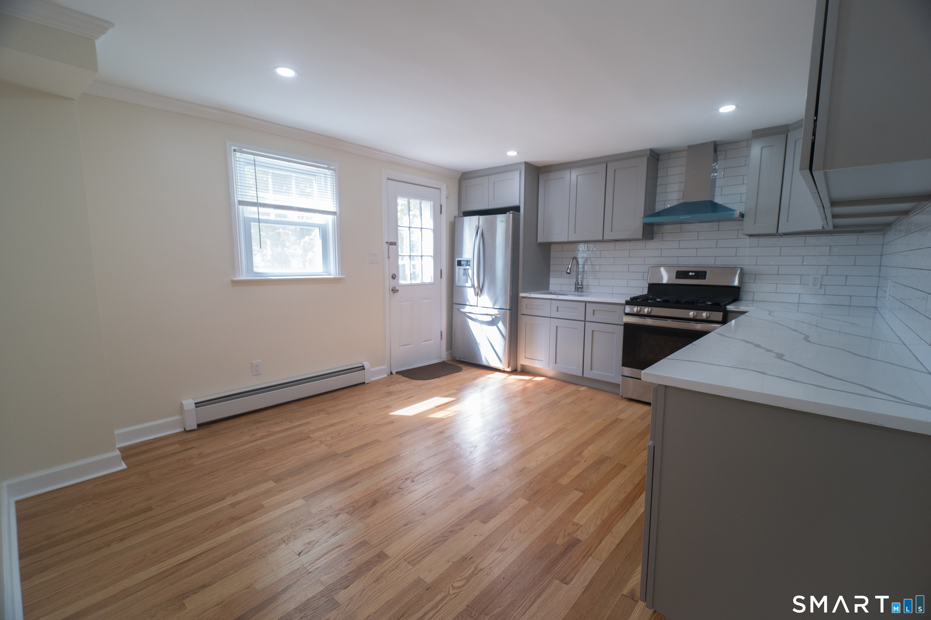 113 Clark Street Bridgeport, CT 06606 - Photo 4 of 27 a kitchen with granite countertop a stove a sink and a refrigerator