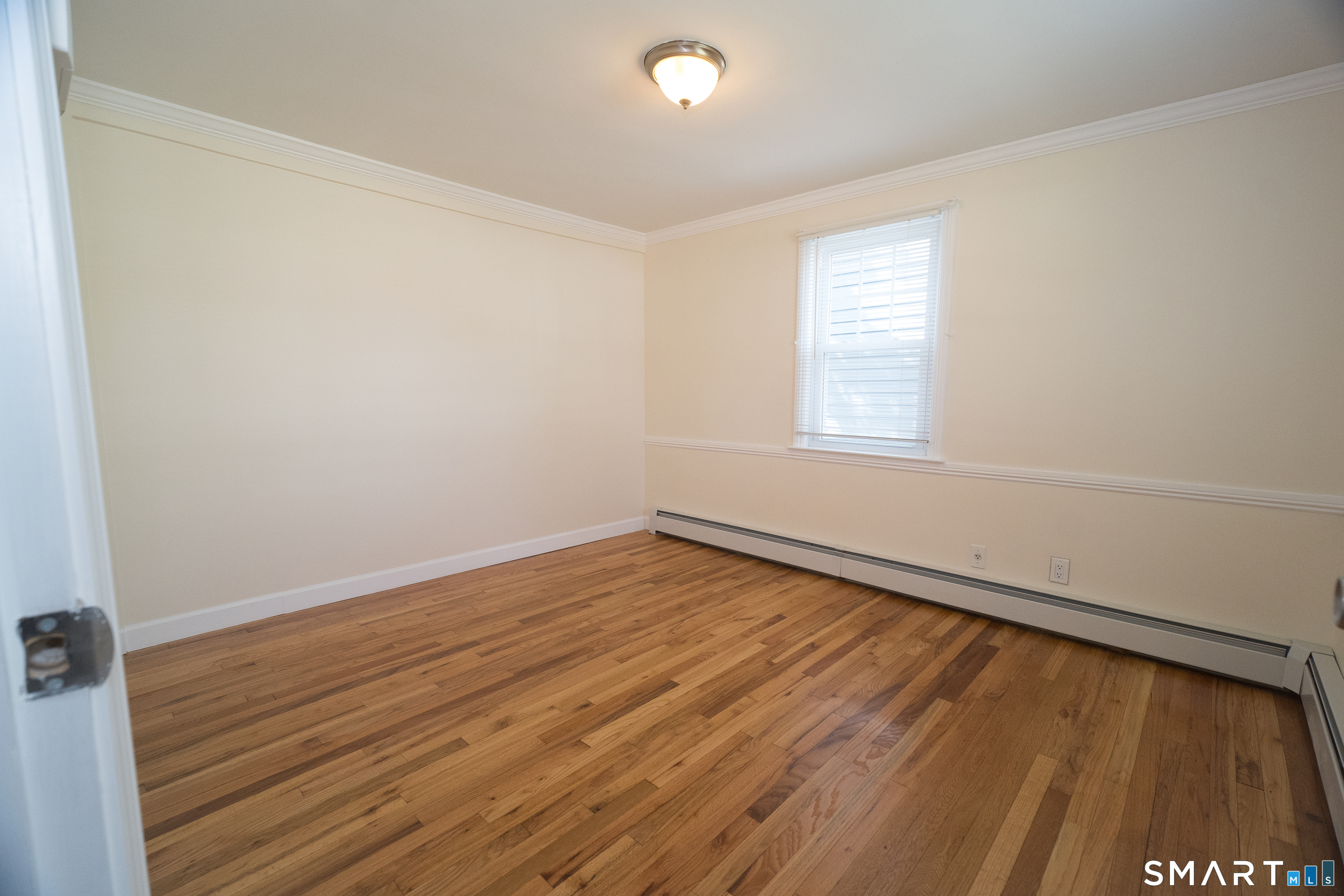 113 Clark Street Bridgeport, CT 06606 - Photo 7 of 27 an empty room with wooden floor and windows