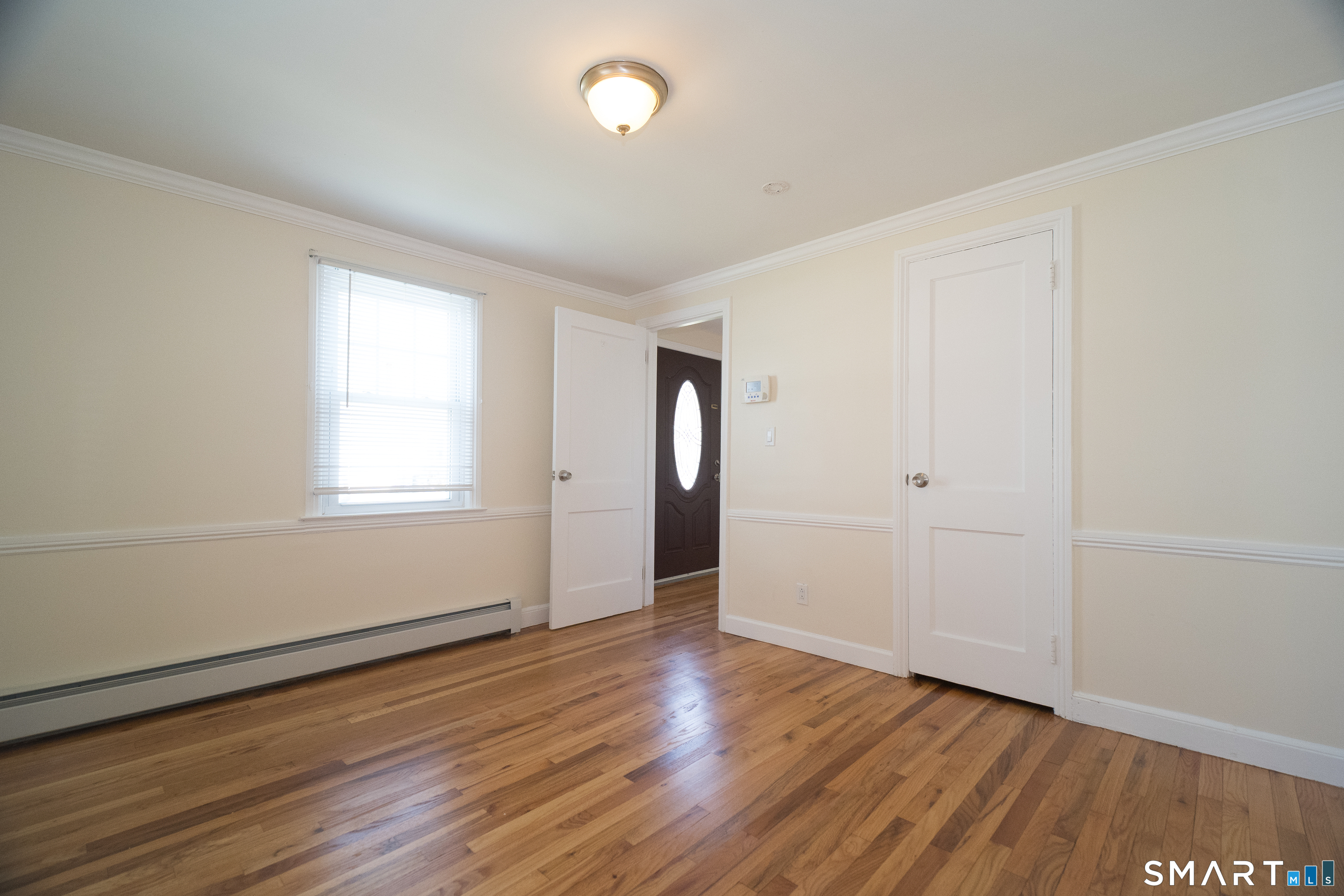 113 Clark Street Bridgeport, CT 06606 - Photo 8 of 27 an empty room with wooden floor and windows